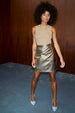 Model wearing Gold Vegan Leather Mini Wrap skirt