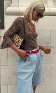 model wears our leopard wrap top with the long denim shorts