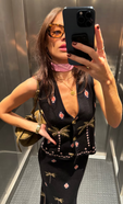 model is taking a selfie wearing the midnight havana waistcoat and nia skirt