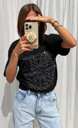 model is taking a selfie wearing the beaded logo black t-shirt with our blue scallop jeans