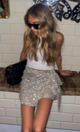 model is wearing the sequin mini jaspre skirt with a ribbed white vest and sunglasses